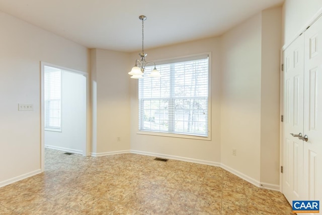 unfurnished room with a notable chandelier