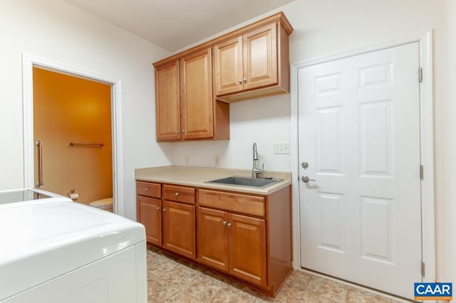 laundry area with sink, light tile patterned floors, and cabinets