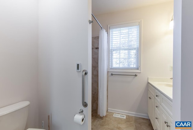 bathroom featuring curtained shower, vanity, and toilet