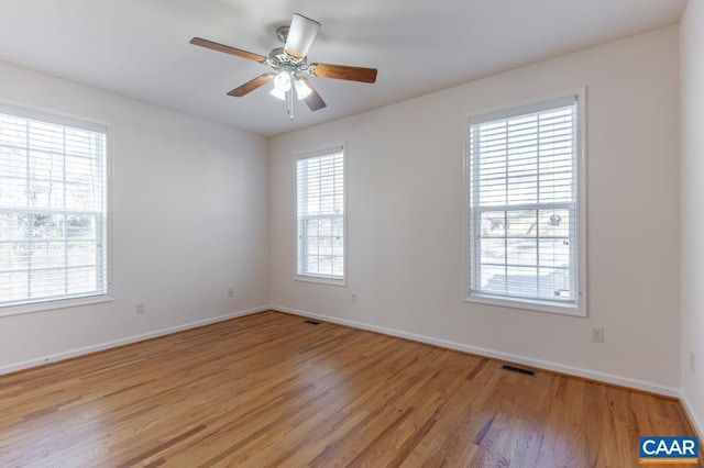 spare room with light hardwood / wood-style flooring, ceiling fan, and a healthy amount of sunlight