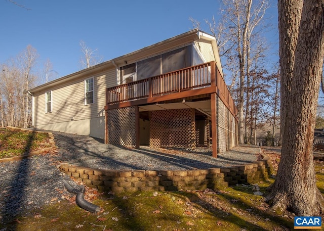 rear view of property featuring a wooden deck