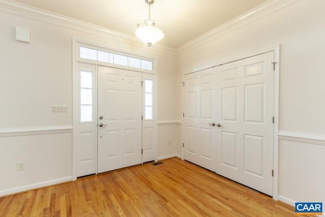 entryway with light hardwood / wood-style floors and ornamental molding