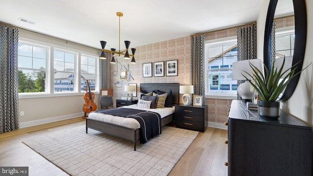 bedroom featuring light hardwood / wood-style flooring and a notable chandelier