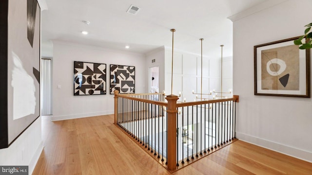 corridor with crown molding and light wood-type flooring