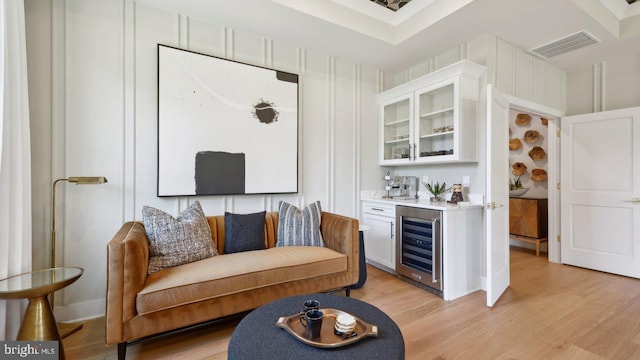 bar with white cabinets, light hardwood / wood-style floors, and wine cooler