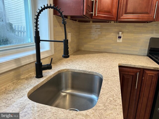 details with light stone countertops, tasteful backsplash, and sink