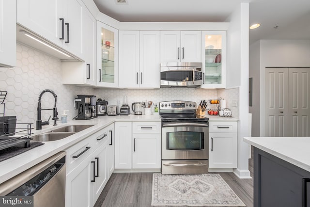 kitchen featuring white cabinets, sink, appliances with stainless steel finishes, and dark wood-type flooring