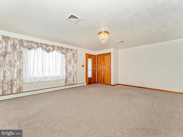 carpeted empty room with a baseboard radiator