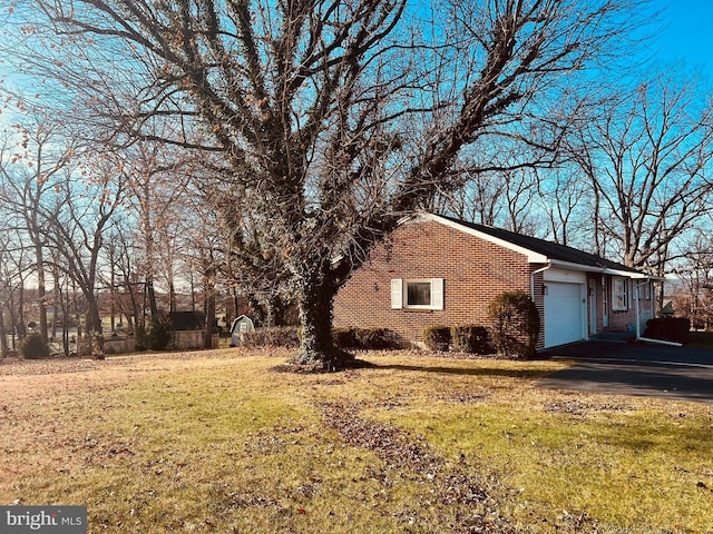 view of side of property featuring a garage and a yard