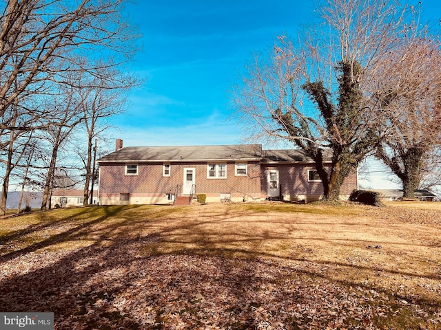 back of property with a lawn