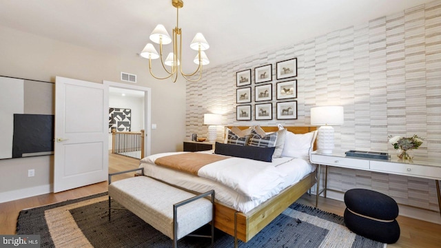 bedroom with wood-type flooring and a notable chandelier