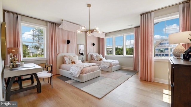 bedroom featuring light wood-type flooring and a chandelier