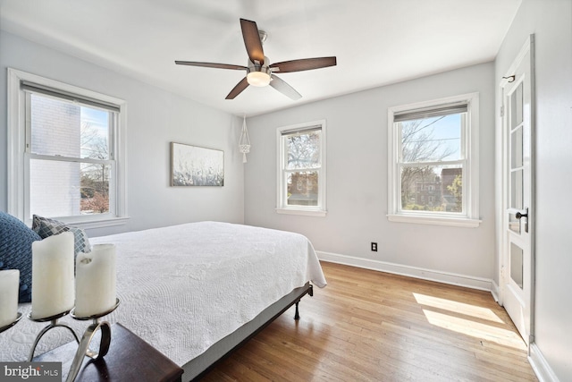 bedroom featuring light hardwood / wood-style flooring, multiple windows, and ceiling fan