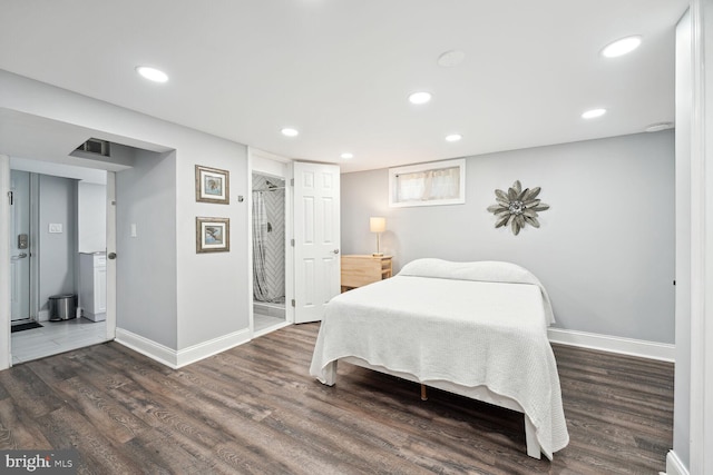 bedroom featuring dark hardwood / wood-style flooring and ensuite bath