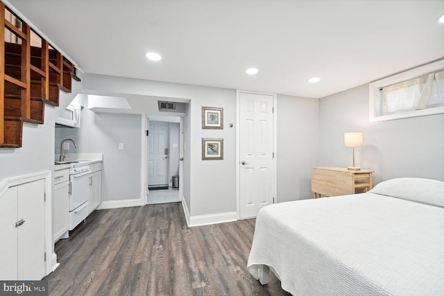 bedroom featuring dark hardwood / wood-style floors and sink