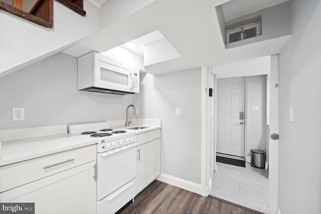 kitchen with sink, white cabinets, dark hardwood / wood-style floors, and white appliances