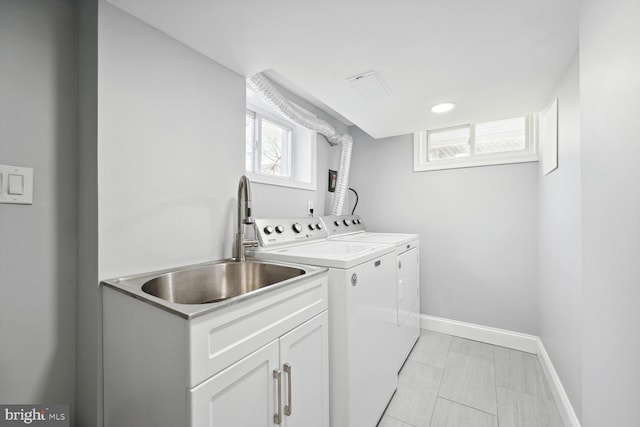 laundry room featuring washer and clothes dryer, cabinets, and sink