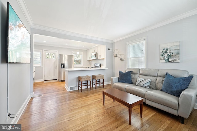 living room with ornamental molding and light wood-type flooring