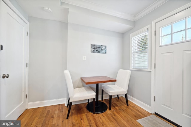 dining space featuring crown molding and light hardwood / wood-style flooring