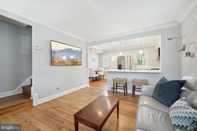 living room featuring crown molding and light wood-type flooring