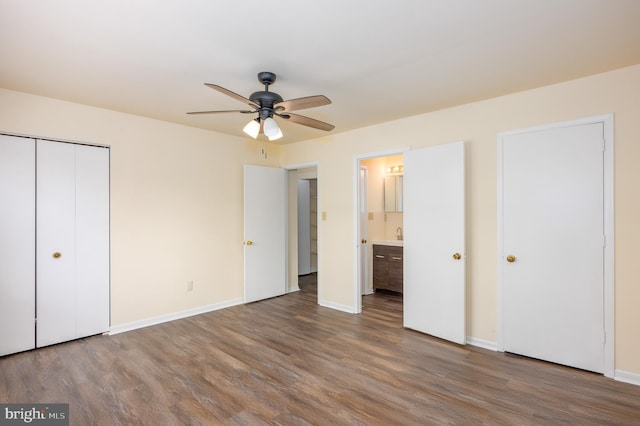 unfurnished bedroom featuring connected bathroom, ceiling fan, and wood-type flooring