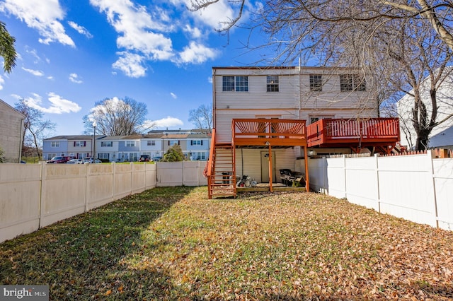 rear view of property with a deck and a yard