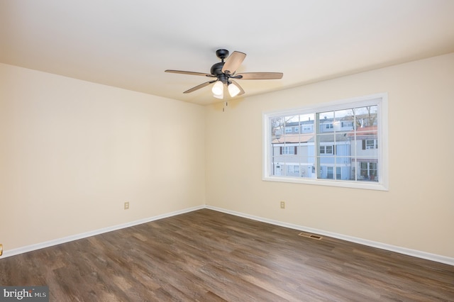 empty room with ceiling fan and dark hardwood / wood-style flooring