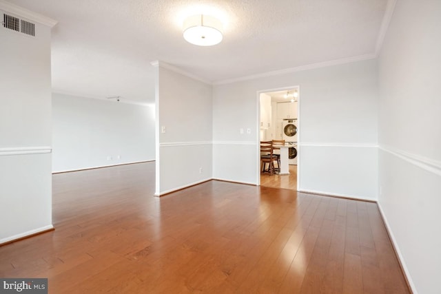 unfurnished room with ornamental molding, wood-type flooring, and baseboards