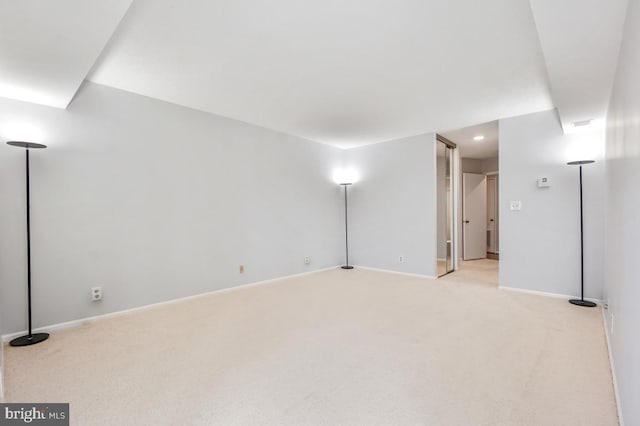 spare room with light colored carpet and baseboards