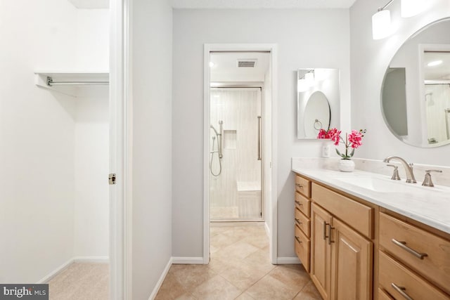 bathroom with visible vents, baseboards, tile patterned floors, vanity, and a shower stall