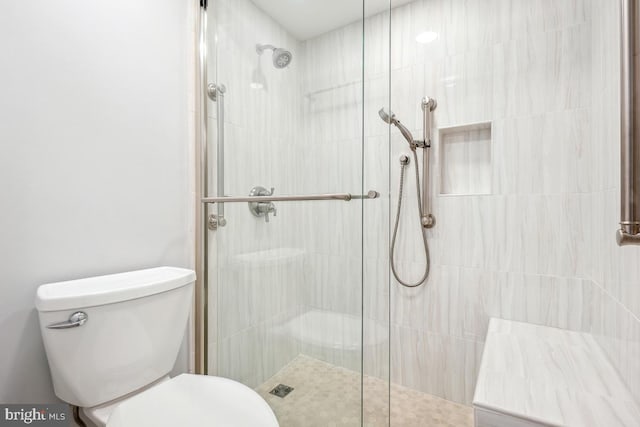 full bath featuring tiled shower and toilet