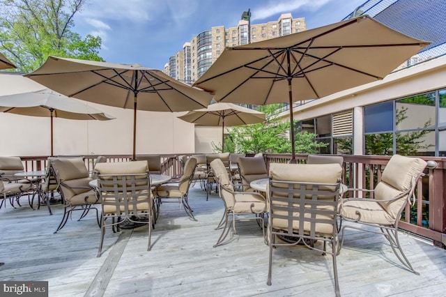 wooden deck featuring outdoor dining space and a city view