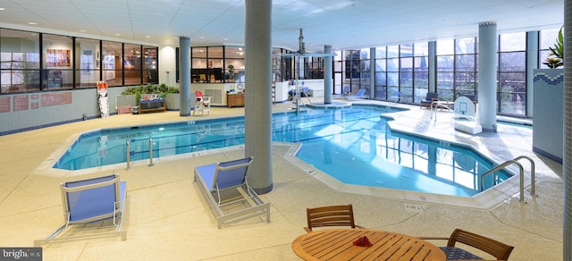 pool featuring a patio area and glass enclosure