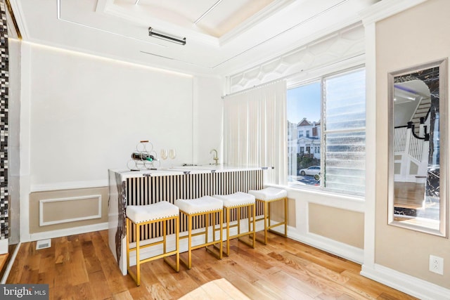 sitting room featuring wood-type flooring, crown molding, and a tray ceiling