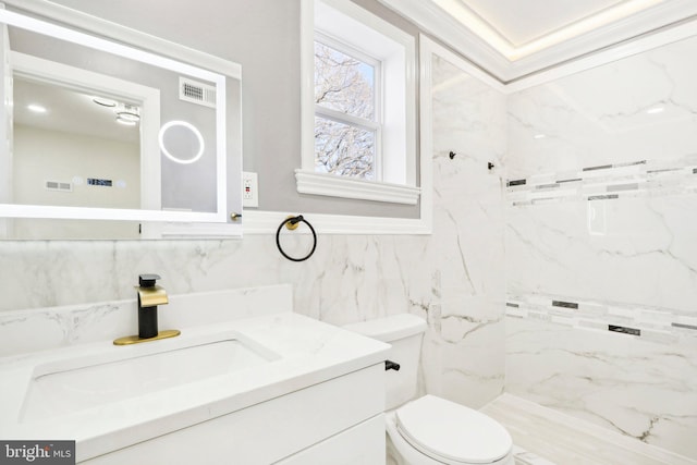 bathroom with vanity, toilet, and tile walls