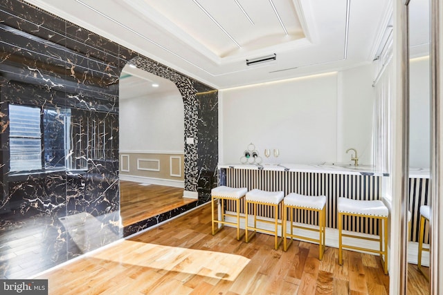 hallway featuring wood-type flooring and a tray ceiling