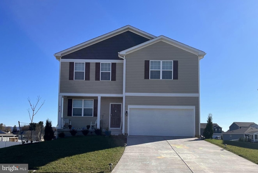 view of property with a garage and a front lawn