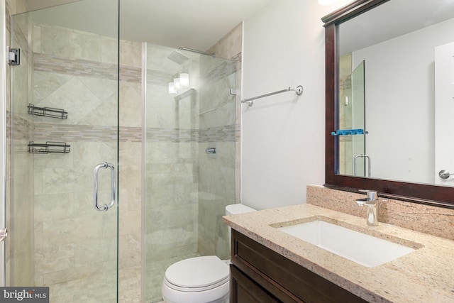 bathroom with an enclosed shower, vanity, and toilet