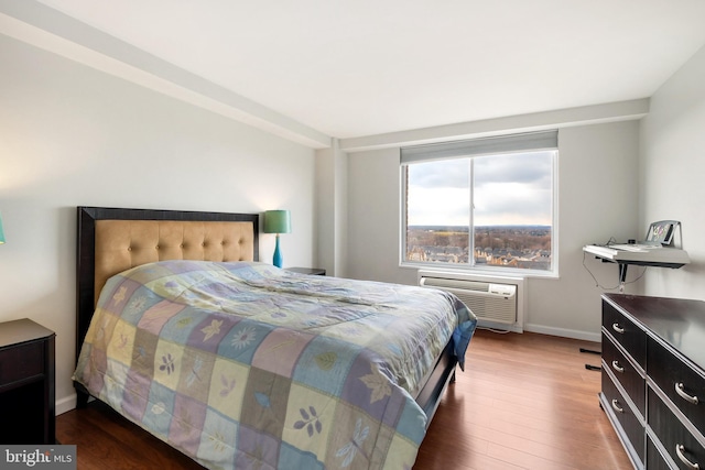 bedroom featuring a wall mounted AC and dark wood-type flooring