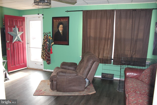 living room featuring a paneled ceiling and hardwood / wood-style floors