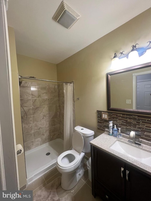 bathroom featuring tasteful backsplash, vanity, tile patterned flooring, toilet, and curtained shower