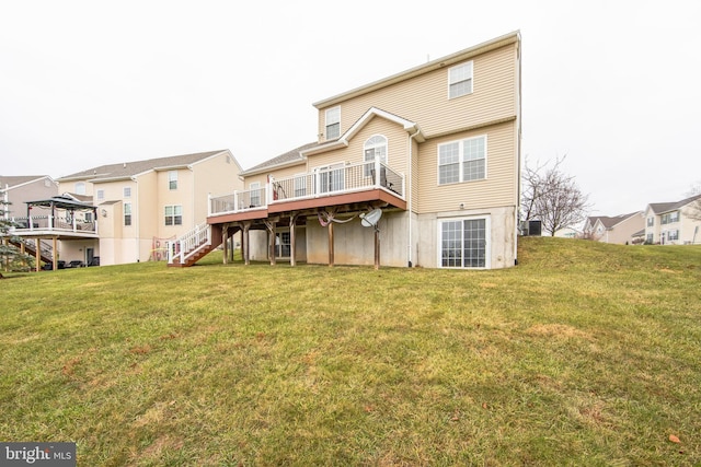 rear view of property with a yard and a deck