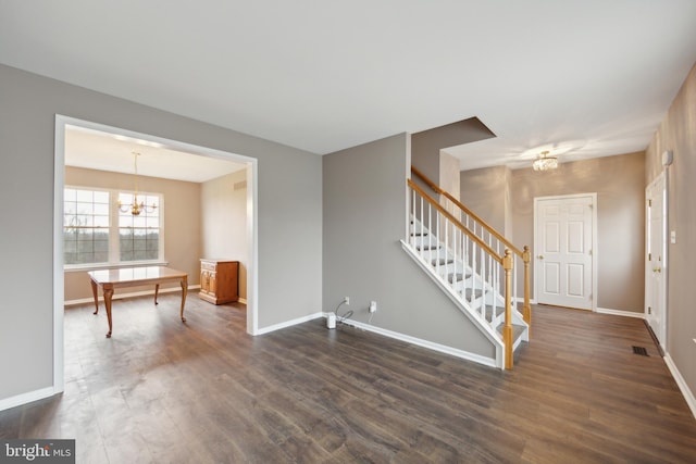 unfurnished room with dark hardwood / wood-style floors and a notable chandelier