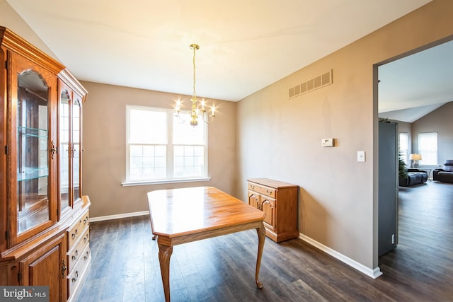 dining room with a wealth of natural light, dark wood-type flooring, lofted ceiling, and a notable chandelier