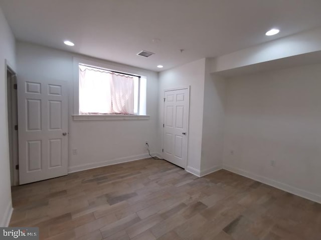 basement with light hardwood / wood-style flooring