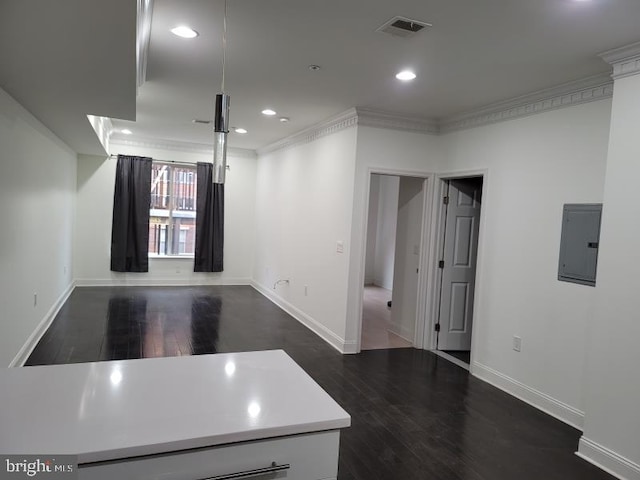 kitchen featuring electric panel, dark hardwood / wood-style flooring, and crown molding