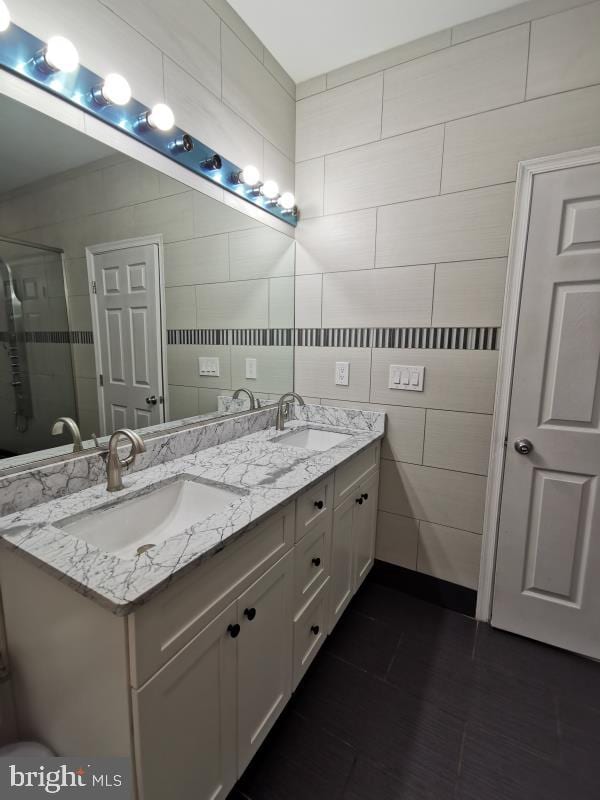 bathroom featuring walk in shower, tile walls, tile patterned floors, and vanity