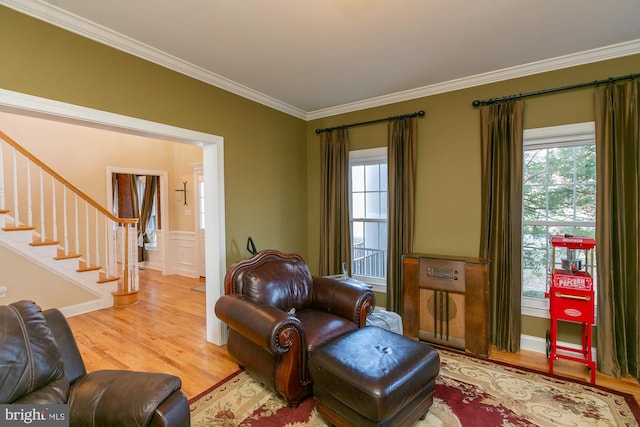 living area with hardwood / wood-style flooring and crown molding