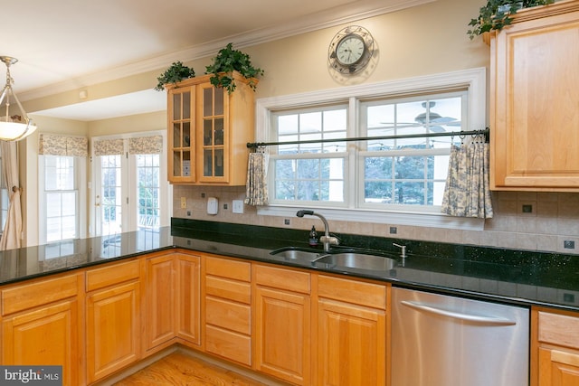 kitchen with pendant lighting, sink, crown molding, and stainless steel dishwasher