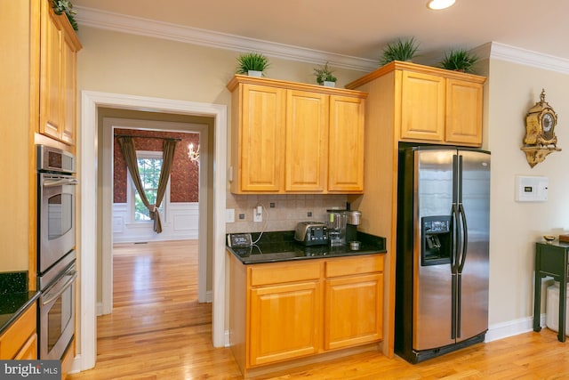 kitchen featuring tasteful backsplash, ornamental molding, appliances with stainless steel finishes, and light hardwood / wood-style floors